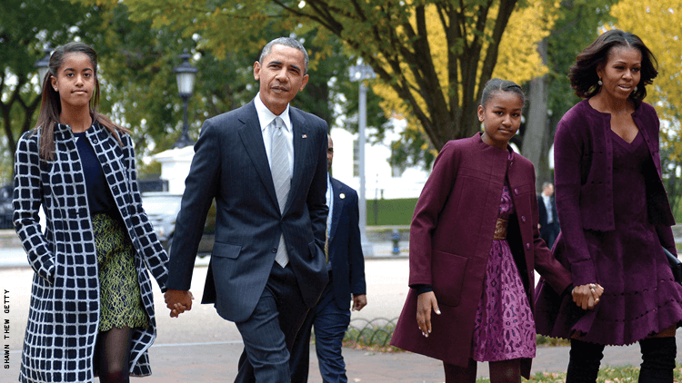 奥巴马总统米歇尔奥巴马玛利亚和萨莎奥巴马都走在街上一个美丽的黑人家庭 