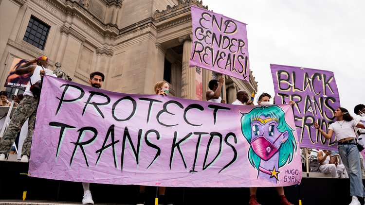 抗议者举着写着“保护跨性别儿童”的标语