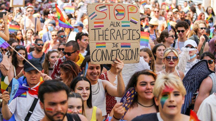 法国取缔了 LGBTQ+ 转换疗法的不可信做法 法国骄傲游行,标有反对转化疗法的标志
